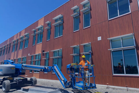 Professional commercial window cleaning using boom lift on large multi-story building in Salem, Oregon – expert high-access service by Dou-Glass team for spotless exterior windows