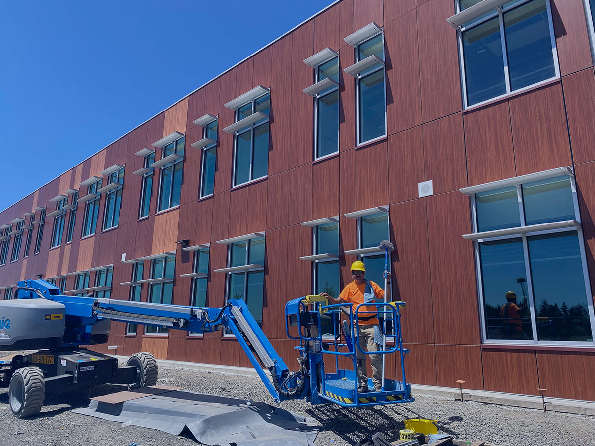 Professional commercial window cleaning using boom lift on large multi-story building in Salem, Oregon – expert high-access service by Dou-Glass team for spotless exterior windows