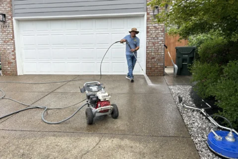 Professional pressure washing of concrete driveway and garage entrance in Keizer, Oregon – safe removal of dirt and grime by Dou-Glass team